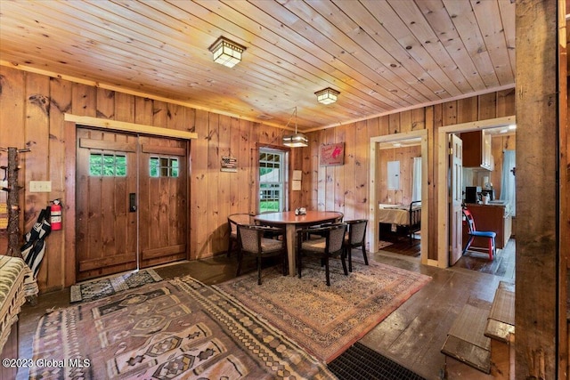 dining area featuring dark hardwood / wood-style flooring, wooden ceiling, and wood walls