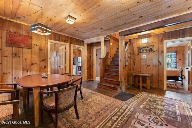 dining area with wood walls, dark hardwood / wood-style floors, and wooden ceiling