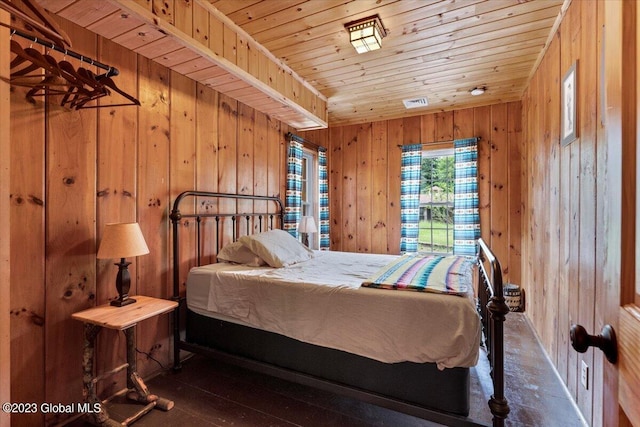 bedroom featuring wooden ceiling, wood walls, and dark wood-type flooring