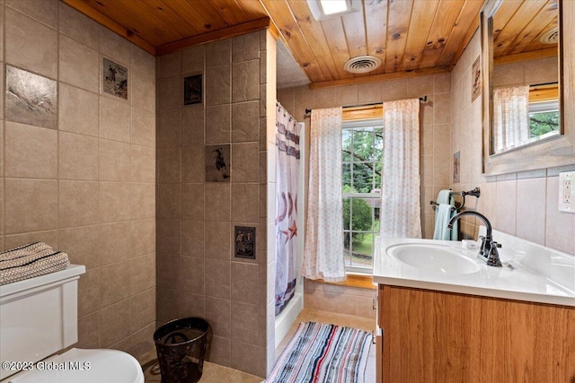 bathroom featuring wooden ceiling, tile flooring, toilet, vanity, and tile walls