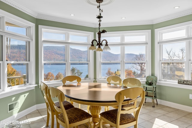 tiled dining area featuring crown molding, a water and mountain view, and a chandelier