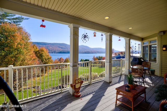 wooden deck featuring a water and mountain view