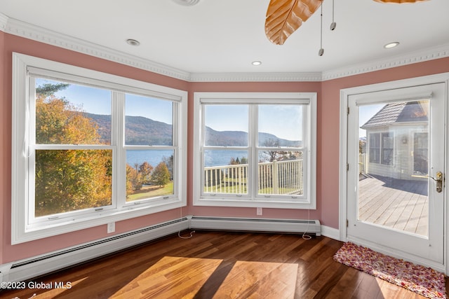 spare room featuring a water and mountain view, dark wood-type flooring, and plenty of natural light