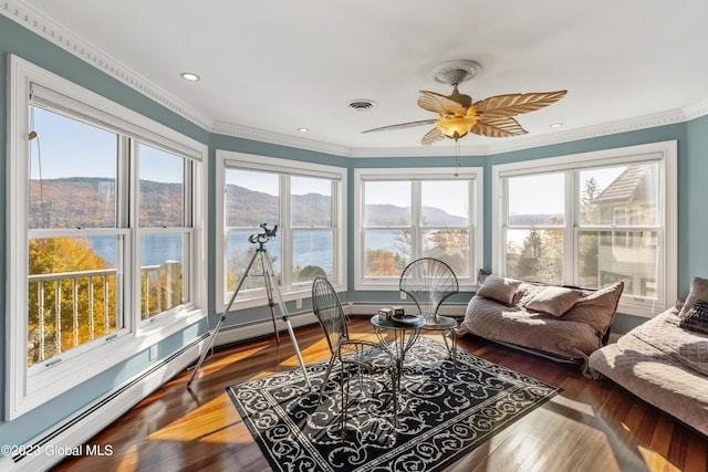 sunroom with a water view and ceiling fan