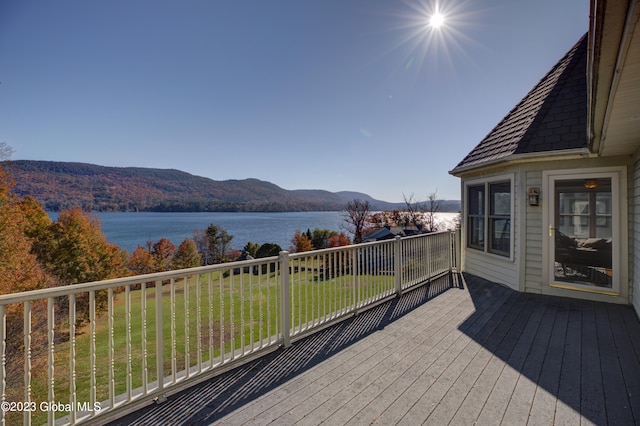 deck with a yard and a water and mountain view