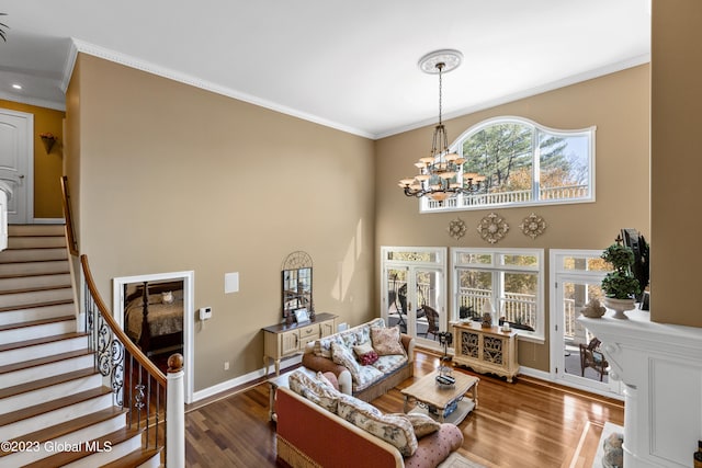 living room featuring crown molding, dark hardwood / wood-style flooring, a notable chandelier, and a towering ceiling