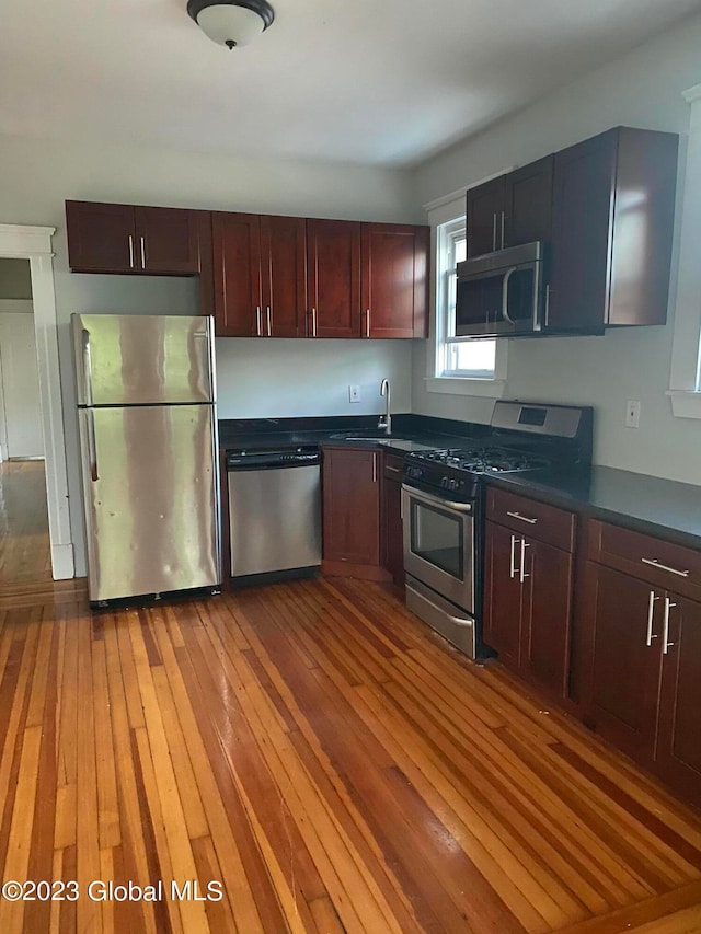 kitchen featuring dark hardwood / wood-style floors, appliances with stainless steel finishes, and sink