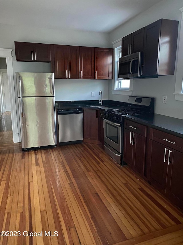 kitchen featuring dark wood-type flooring, appliances with stainless steel finishes, and sink