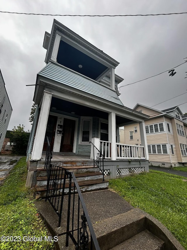 view of front of property featuring covered porch and a front yard