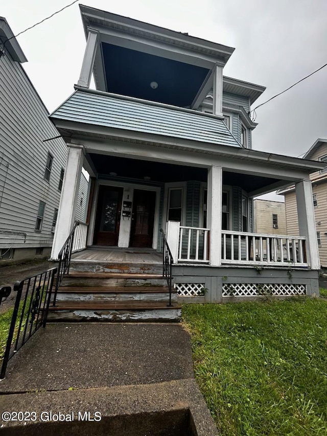 view of front facade featuring a front yard and covered porch