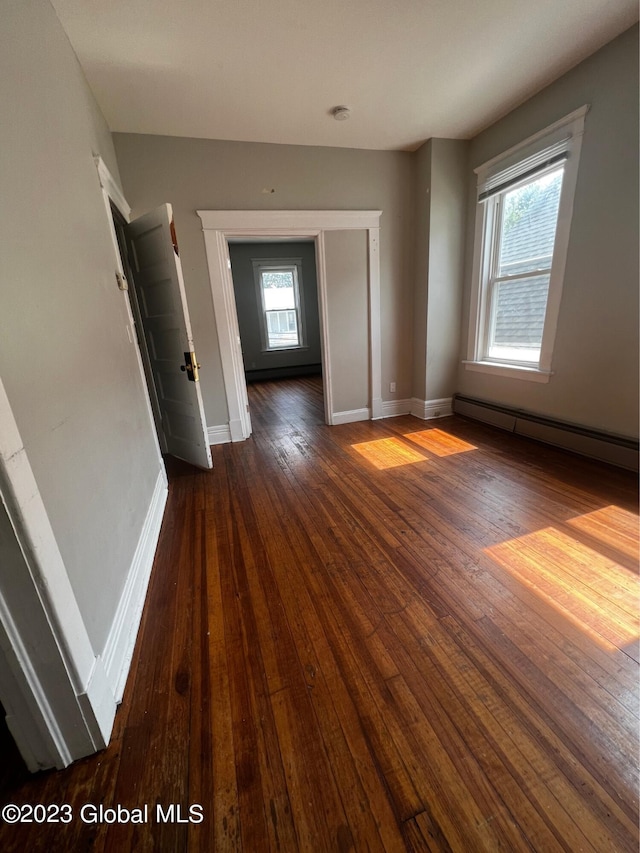 spare room featuring a baseboard radiator and dark hardwood / wood-style floors