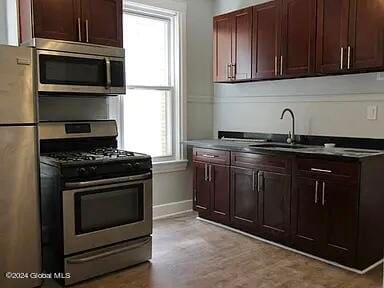 kitchen featuring light wood-type flooring, appliances with stainless steel finishes, and sink