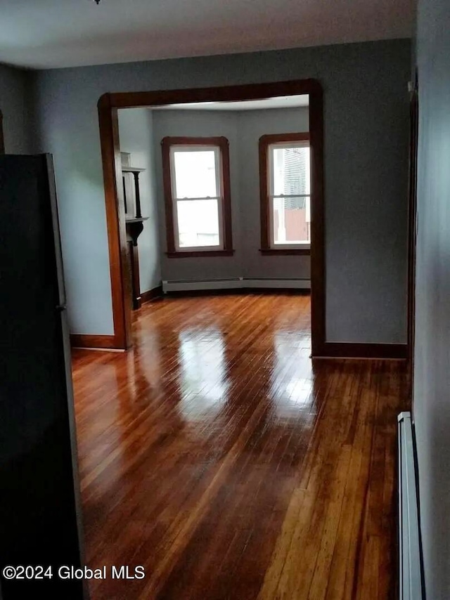 spare room with a baseboard heating unit and hardwood / wood-style floors