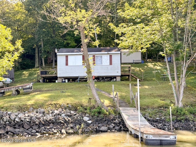 view of front of home featuring a water view, a storage shed, and a front yard