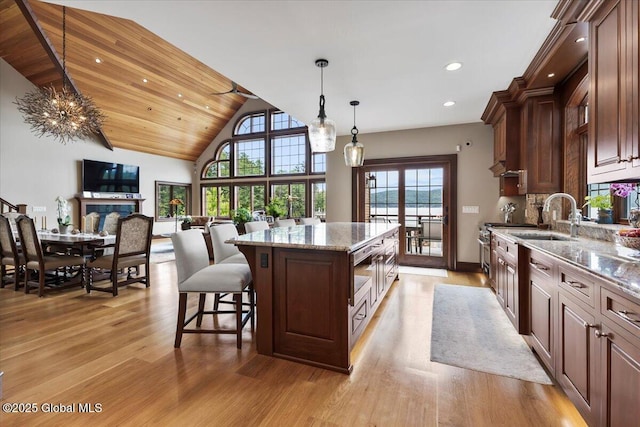 41 Trinity Rock Rd, Lake George, NY 12845 - kitchen with a center island, light wood-type flooring, open floor plan, light stone countertops, and decorative light fixtures