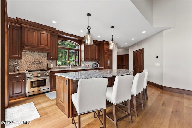 41 Trinity Rock Rd, Lake George, NY 12845 - kitchen with stainless steel stove, light wood-style flooring, backsplash, recessed lighting, and a center island
