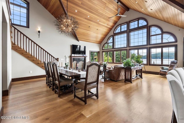 41 Trinity Rock Rd, Lake George, NY 12845 - dining area with high vaulted ceiling, a wooden ceiling with exposed beams, wood finished floors, stairway, and a fireplace