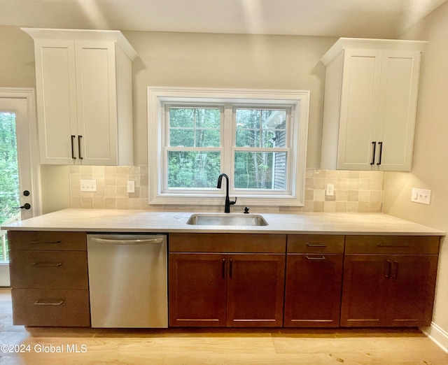 kitchen with tasteful backsplash, sink, white cabinetry, and dishwasher