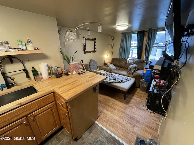 82 N Williams St, Whitehall, NY 12887 - kitchen featuring brown cabinets, a sink, a peninsula, open floor plan, and butcher block counters