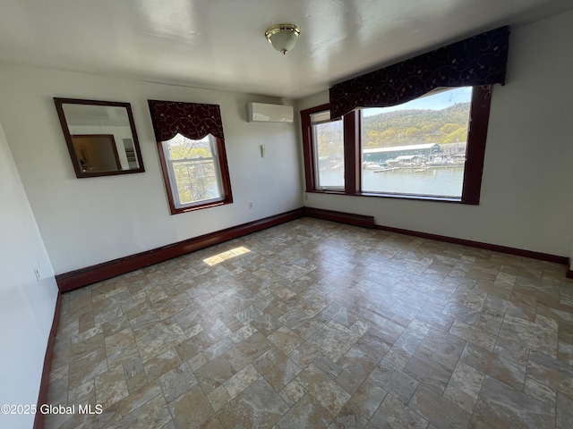 82 N Williams St, Whitehall, NY 12887 - empty room featuring baseboards, stone tile floors, an AC wall unit, and a wealth of natural light