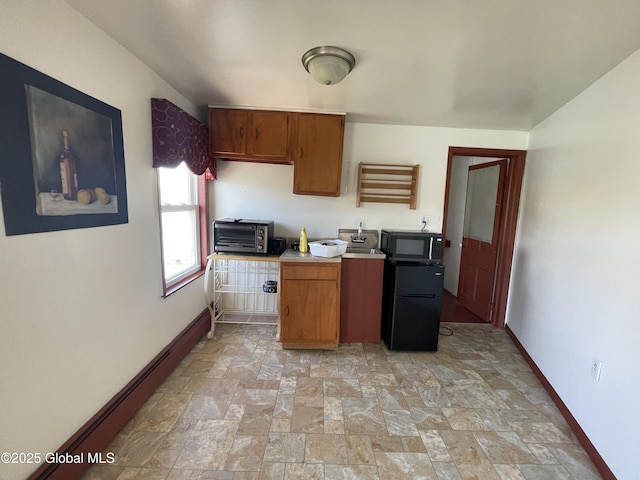 82 N Williams St, Whitehall, NY 12887 - kitchen with stone finish floor, light countertops, baseboards, a toaster, and black appliances