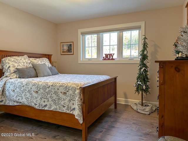 bedroom with baseboards and wood finished floors