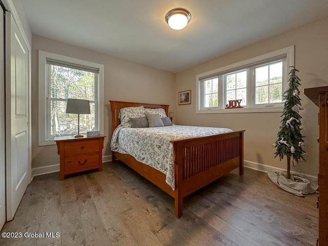 bedroom with light wood-type flooring and baseboards