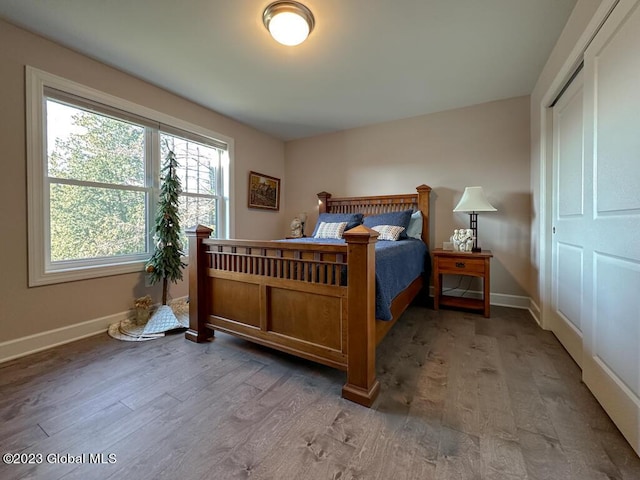 bedroom with baseboards and wood finished floors