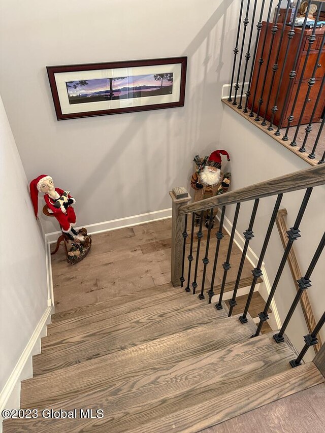 staircase with wood finished floors and baseboards