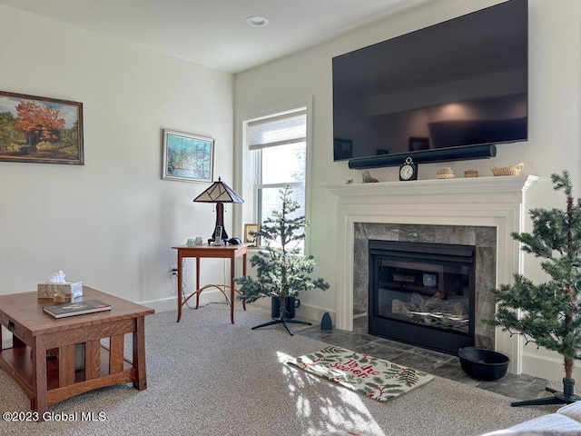 carpeted living area with a fireplace and baseboards