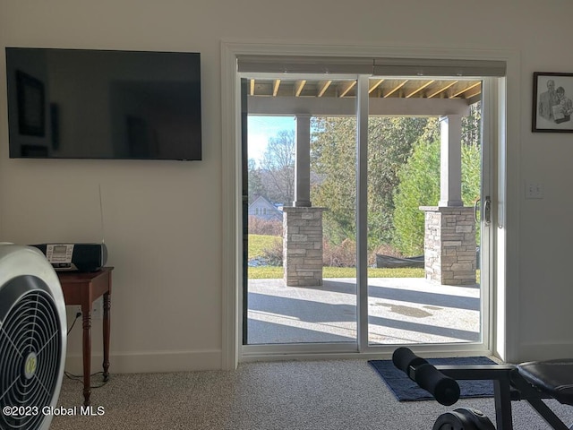 doorway with carpet flooring and baseboards