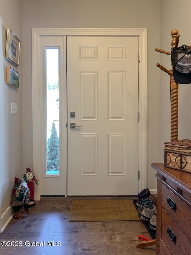 foyer featuring baseboards and wood finished floors