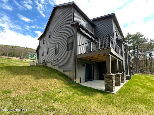 rear view of property featuring central air condition unit, a yard, a deck, and a patio