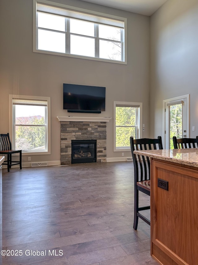 9 Hill Crest Ln Unit 3, Lake George, NY 12845 - living room with a fireplace, wood finished floors, visible vents, and a high ceiling