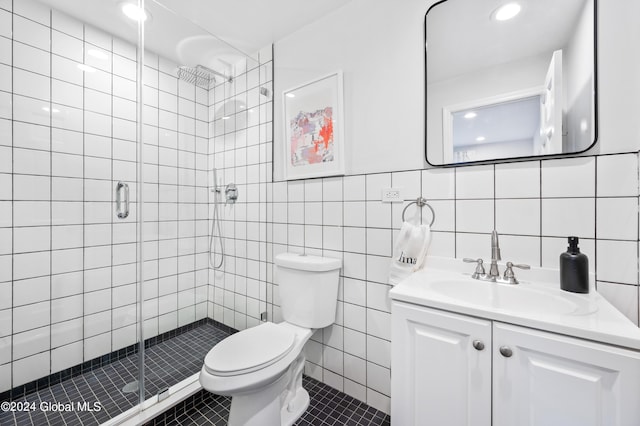 bathroom featuring vanity, tile patterned floors, toilet, tile walls, and a shower with shower door