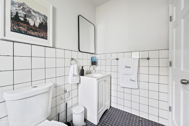 bathroom with tile patterned floors, vanity, toilet, and tile walls