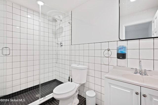 bathroom with tile patterned floors, a shower with door, vanity, and tile walls