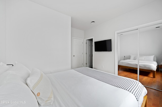 bedroom with wood-type flooring and a closet