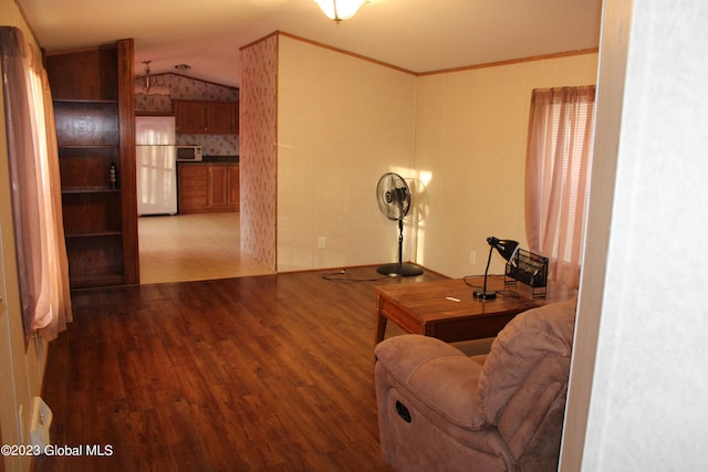 living room with vaulted ceiling, crown molding, and hardwood / wood-style floors