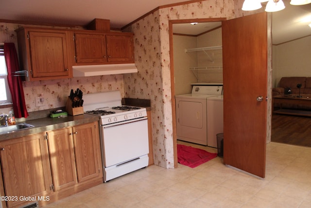 kitchen featuring sink, crown molding, white range with gas stovetop, independent washer and dryer, and exhaust hood