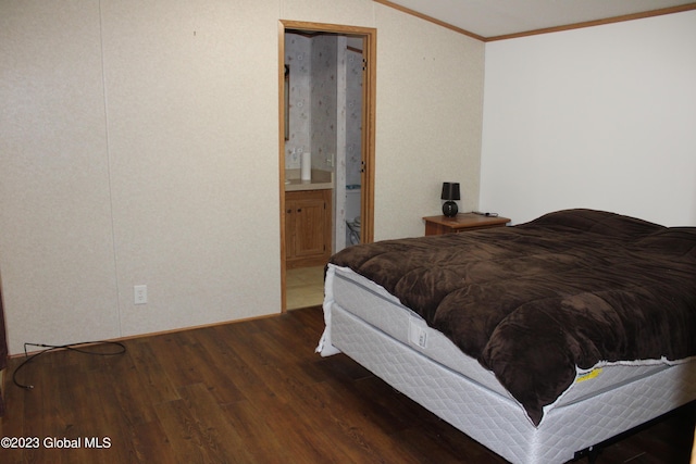 bedroom with dark hardwood / wood-style flooring, ornamental molding, and ensuite bath