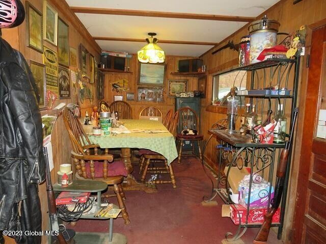 dining area featuring wood walls and carpet flooring