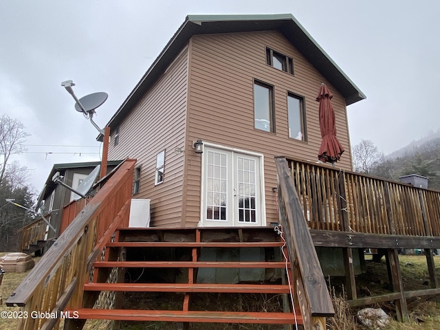 rear view of house with a deck and french doors