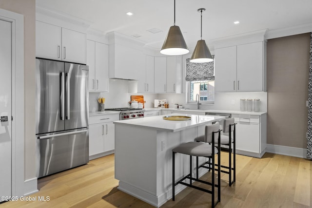 kitchen featuring a kitchen island, a breakfast bar, light countertops, custom range hood, and appliances with stainless steel finishes