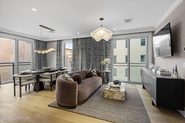 living area with crown molding, recessed lighting, visible vents, and light wood finished floors