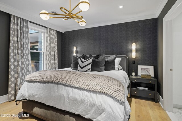 bedroom featuring wood finished floors, baseboards, wallpapered walls, ornamental molding, and a chandelier