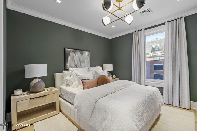 bedroom featuring baseboards, visible vents, light wood finished floors, and ornamental molding