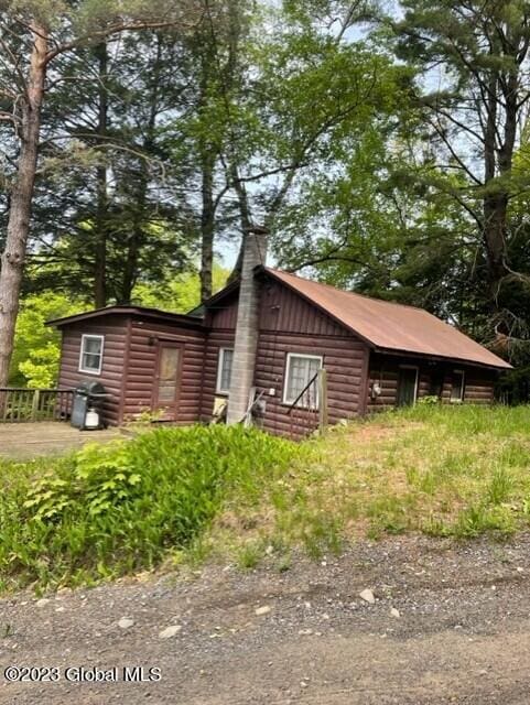 exterior space featuring a chimney and faux log siding