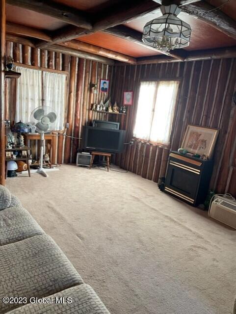 living room featuring beam ceiling, carpet, and coffered ceiling