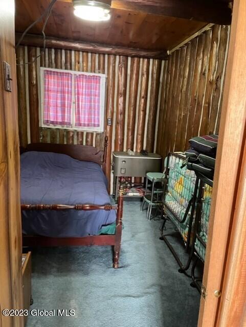 unfurnished bedroom featuring wood walls and carpet